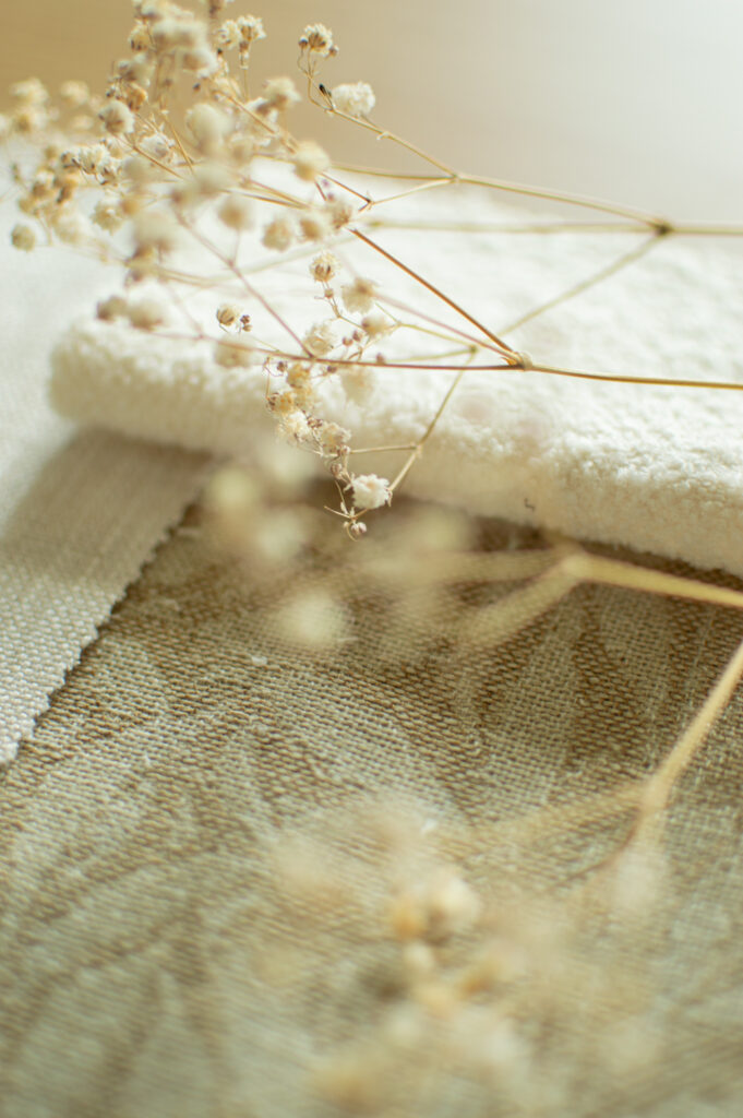Materialprover med textilier, struktur och naturmaterial för ett harmoniskt inredningskoncept.